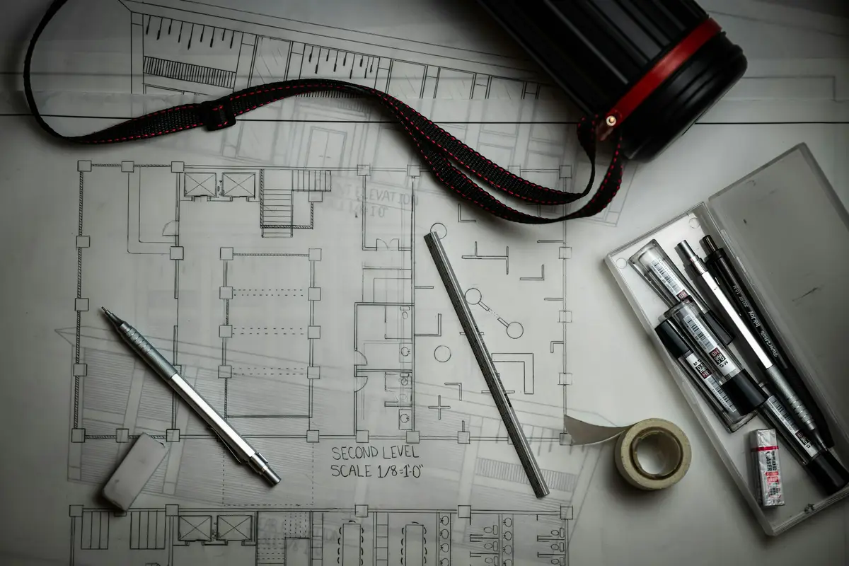 Planos de arquitectura con lápices y una regla metálica